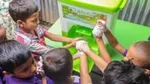 Group of small children washing their hands with soap using a HappyTap portable sink.