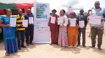 Group of eight smallholder cocoa farmers holding up their land tenure documents at a presentation ceremony.